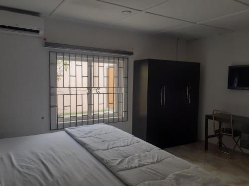 Un dormitorio con una cama grande y una ventana en Biddex Lodge & Hotels, en Benin City