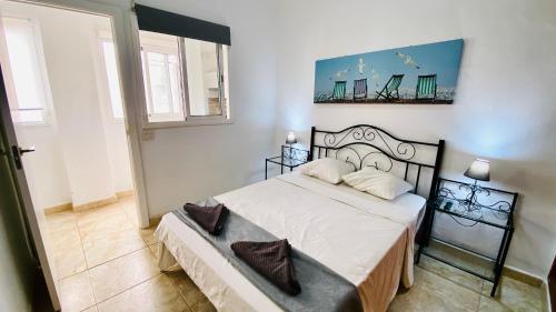 une chambre avec un lit et un tableau au mur dans l'établissement Piso en el centro del Puerto De la Cruz, à Puerto de la Cruz