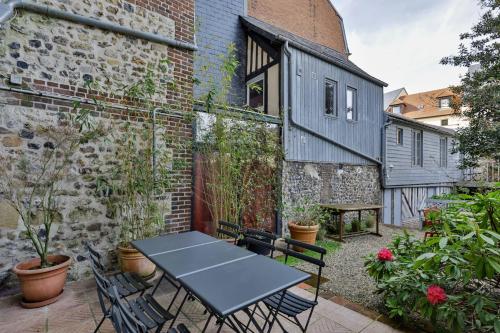 un patio avec une table et des chaises devant un bâtiment dans l'établissement La Maison de Honfleur Atypical house Honfleur center 12P, à Honfleur