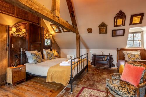 une chambre avec un lit et une chaise dans l'établissement La Maison de Honfleur Atypical house Honfleur center 12P, à Honfleur