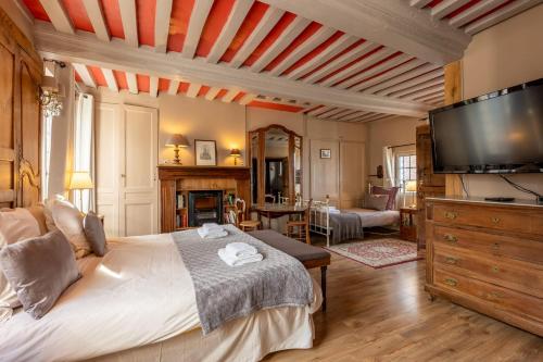 une chambre avec un grand lit et une télévision à écran plat dans l'établissement La Maison de Honfleur Atypical house Honfleur center 12P, à Honfleur
