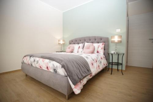 - une chambre avec un grand lit et des oreillers roses dans l'établissement Al Tredici, à Ardea