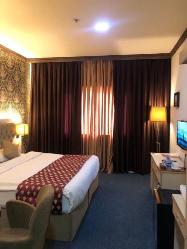 a hotel room with a bed and a desk at Hotel Seever in Erbil