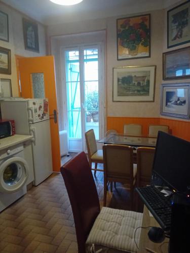 Il comprend un salon avec une table et une cuisine équipée d'un réfrigérateur. dans l'établissement Chambre d hôte artistique cannes, à Cannes