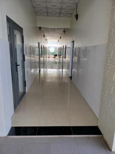 an empty hallway of a building with doors and windows at Nhà trọ Hương Nguyên in Dồng Xoài