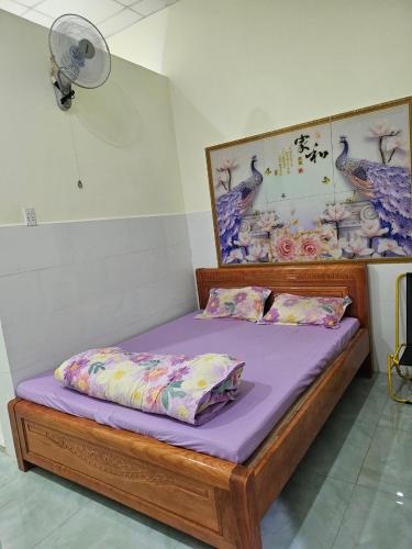 Bett mit lila Bettwäsche und Kissen in einem Zimmer in der Unterkunft Nhà trọ Hương Nguyên in Dồng Xoài
