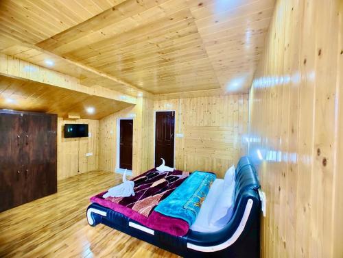 uma cama num quarto com uma parede de madeira em Lady Pahalgam Resort Operated By Zaara Resorts em Pahalgam
