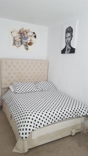 a bedroom with a bed with a black and white comforter at Family home with easy commute to London! in Croydon