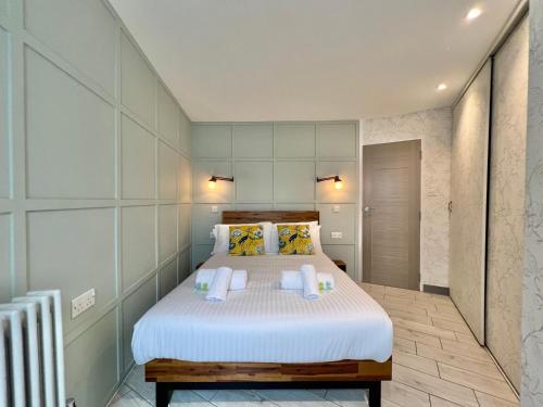 a bedroom with a bed with white sheets and yellow pillows at Lovely contemporary ground floor apartment. in Dean