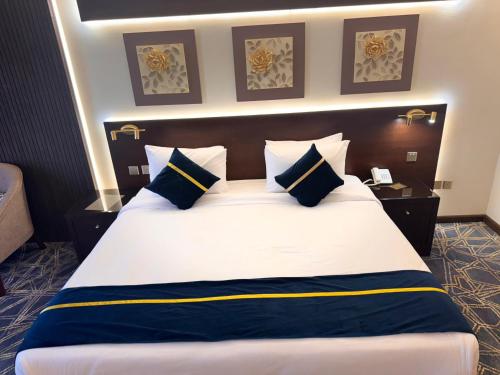 una camera da letto con un grande letto con cuscini blu e bianchi di فندق سنبات بلاتينيوم a Jazan