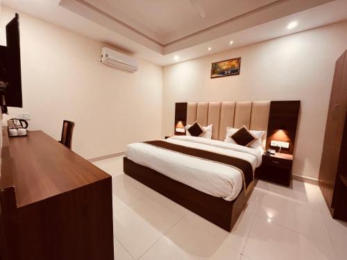 蒙納的住宿－Gamla INN, Munnar，一间卧室配有一张大床和一张书桌