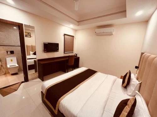 um quarto de hotel com uma cama e uma secretária em Gamla INN, Munnar em Munnar