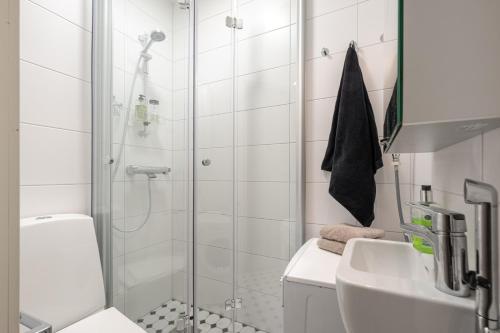 ein Bad mit einer Dusche, einem WC und einem Waschbecken in der Unterkunft Cosy, brand new apartment in best area in Helsinki