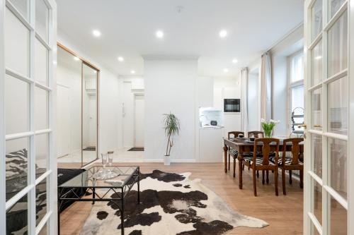 a living room with a table and chairs and a dining room at Cosy, brand new apartment in best area in Helsinki