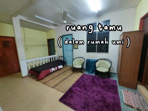 ein Schlafzimmer mit einem Bett und zwei Stühlen in einem Zimmer in der Unterkunft Dangau TokWan in Pokok Sena