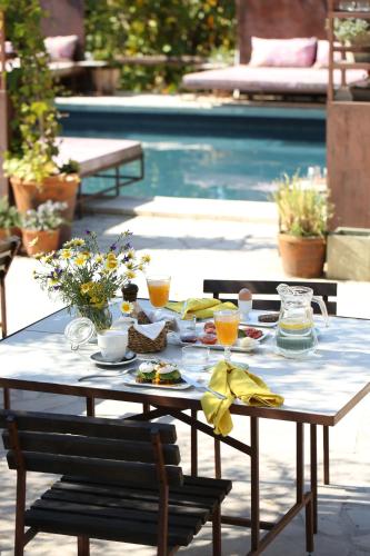 einen Tisch mit Speisen und Getränken neben einem Pool in der Unterkunft Finca Legado Ibiza in Santa Eulària des Riu
