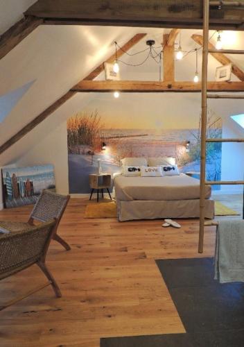 a bedroom with a large bed in a attic at Céshap - Chambres d'hôtes avec Jacuzzi in Taden