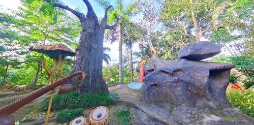 a garden with a tree and a playground at Wayanad Royal Stream in Kalpetta