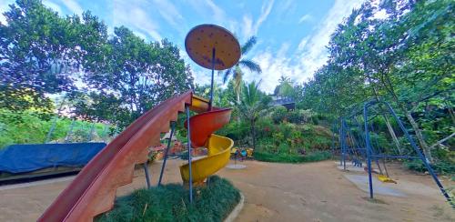 a playground with a slide in a park at Wayanad Royal Stream in Kalpetta