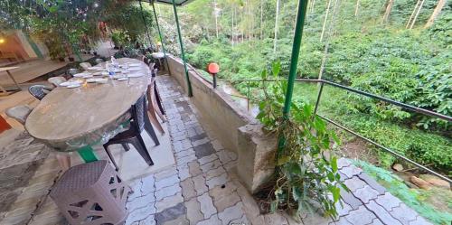 a wooden table and chairs on a patio at Wayanad Royal Stream in Kalpetta