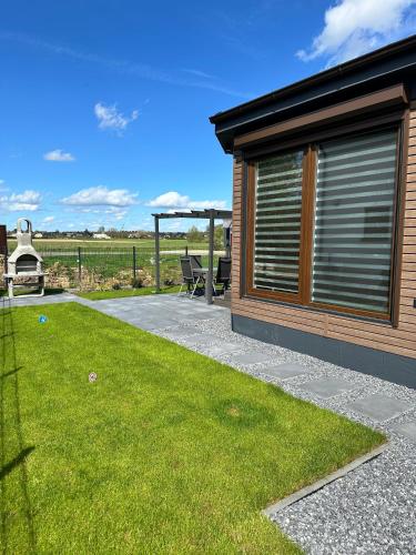 a patio with a gazebo next to a yard at Ferienhaus am Seepark -J&K in Goch