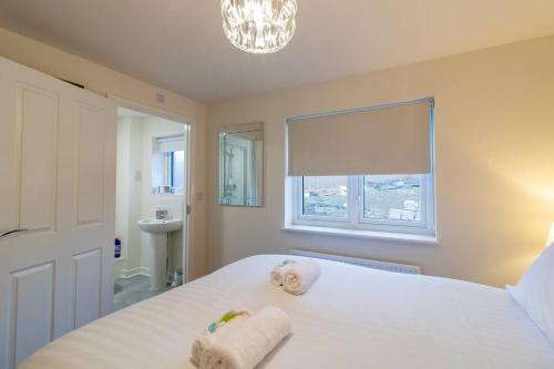a bedroom with a white bed with towels on it at Pass the Keys Modern comfortable House in Elswick
