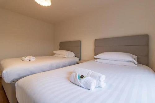 two beds in a room with white towels on them at Pass the Keys Modern comfortable House in Elswick