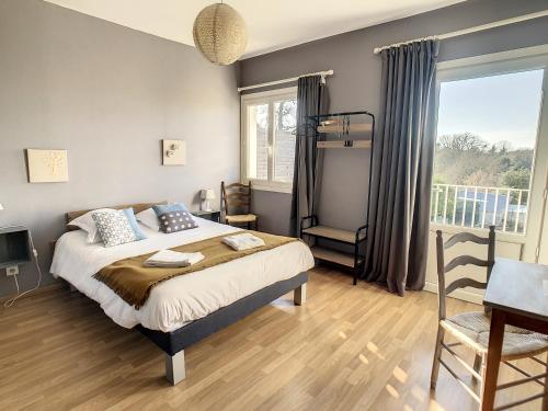 a bedroom with a bed and a desk and a window at Logis Hôtel Restaurant La Borie in Saint-Geniès