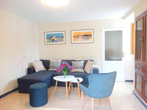 a living room with a blue couch and a table at Casa Calvo in Viveiro