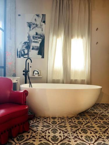 a bathroom with a large white tub and a window at Loft a 5min de la playa in Valencia