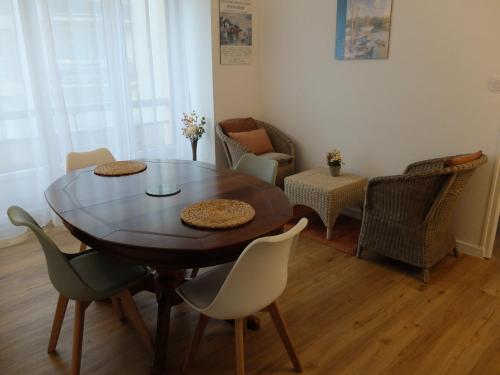 une salle à manger avec une table et des chaises en bois dans l'établissement T2 à 150 M du centre-ville, parking privé, à Vannes