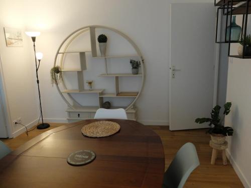 une salle à manger avec une table et un miroir dans l'établissement T2 à 150 M du centre-ville, parking privé, à Vannes