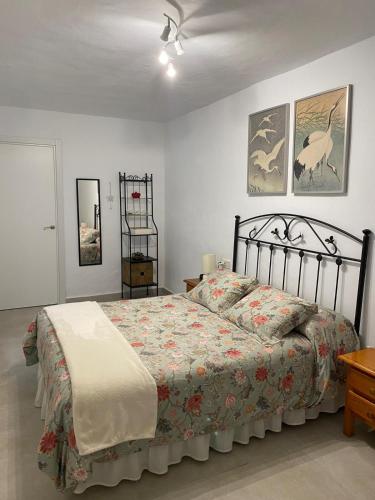 a bedroom with a large bed with a floral bedspread at La Casa Rosales in Alora
