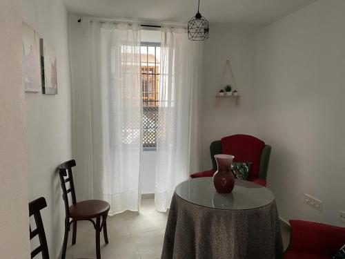 a living room with a table and chairs and a window at La Casa Rosales in Alora