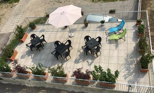 an overhead view of a patio with tables and an umbrella at The Tulip: 2 rooms apartment in Ronzo Chienis