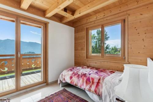 a bedroom with a bed and large windows at Winterfell in Leysin