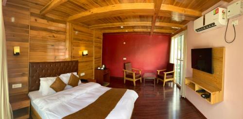 a bedroom with a bed and a red wall at Saksham INN in Jaipur