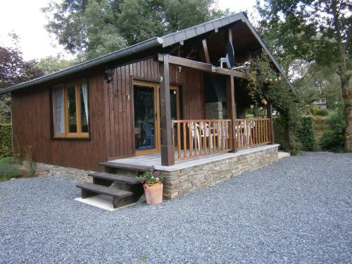 a small cabin with a porch and stairs to it at Le Chalet Pré de la Fontaine in Paliseul