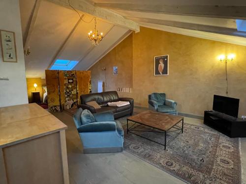 sala de estar con sofá, sillas y mesa en La Gandonne en Caderousse