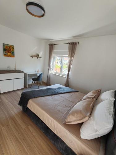 a bedroom with a large bed and a window at Sunny Apartment in Kali