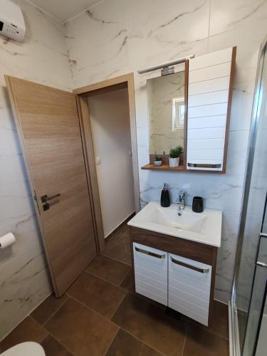 a bathroom with a white sink and a mirror at Sunny Apartment in Kali