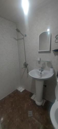 La salle de bains blanche est pourvue d'un lavabo et d'un miroir. dans l'établissement Cozy House I, à Tbilissi