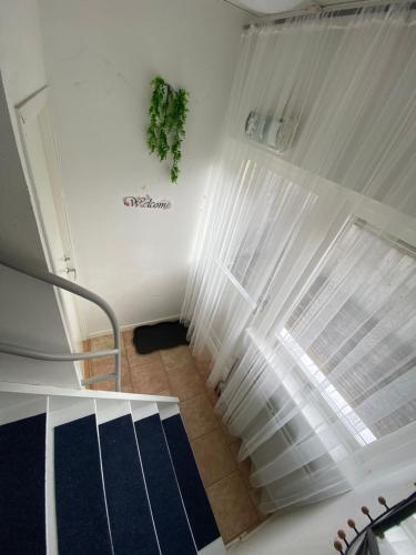 a staircase with white curtains in a room at Hyllstofta lägenhet in Klippan