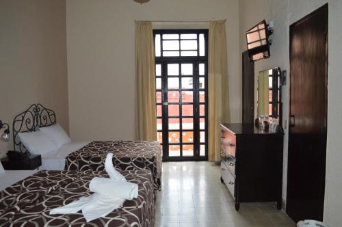 a bedroom with a bed with a white swan on it at Hotel Colon Merida in Mérida
