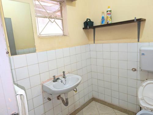 a bathroom with a sink and a toilet at Dans place in Moshi