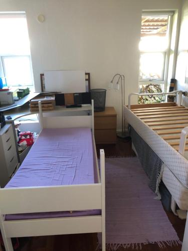 1 Schlafzimmer mit 2 Betten, einem Schreibtisch und Fenstern in der Unterkunft Great house in beautiful surroundings in Aalborg