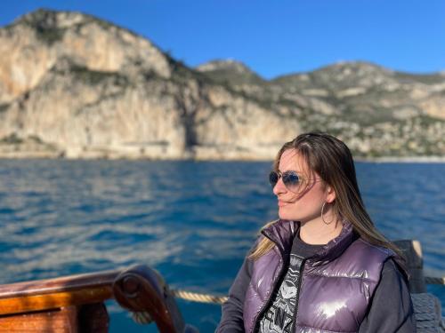 a woman sitting on a boat in the water at Ezevacances Studio Capuccino vue mer 5 mn plage 7 mn gare Wifi in Èze