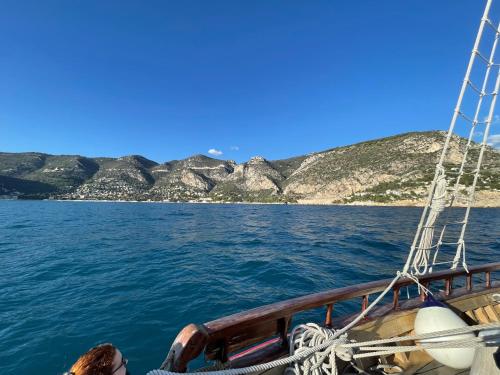 a boat in the water with mountains in the background at Ezevacances Studio Capuccino vue mer 5 mn plage 7 mn gare Wifi in Èze