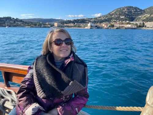 a woman sitting on a boat on the water at Ezevacances Studio Capuccino vue mer 5 mn plage 7 mn gare Wifi in Èze