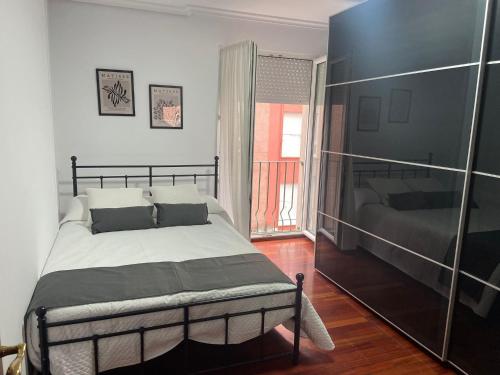 - une chambre avec un grand lit et une fenêtre dans l'établissement Vivienda vacacional: Los Abuelos, à San Vicente de la Barquera